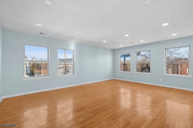 219 Clinton Place Newark, NJ 07112 - Photo 7 of 21 a view of an empty room with a window and wooden floor