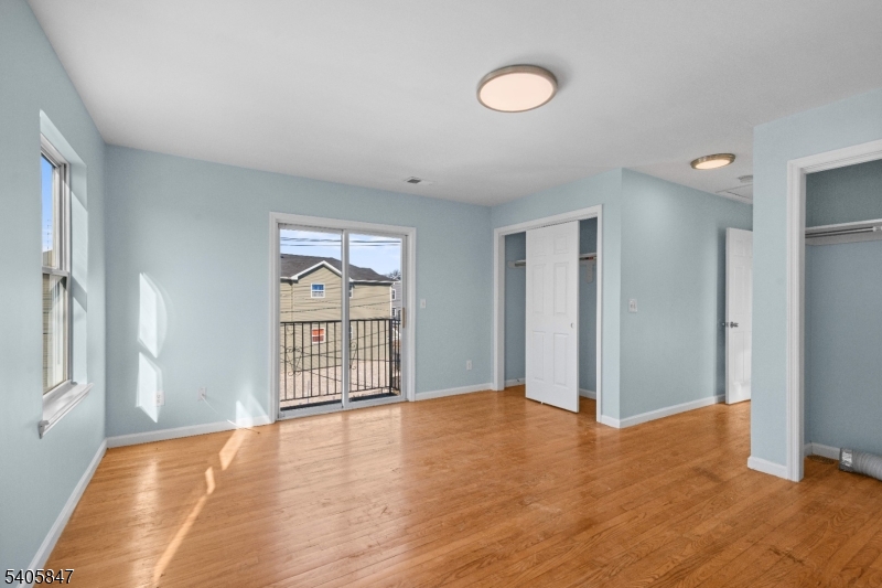 219 Clinton Place Newark, NJ 07112 - Photo 9 of 21 an empty room with wooden floor and windows