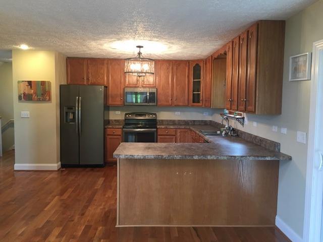 183 Midkiff Road Southeast Floyd, VA 24091 - Photo 11 of 35 a kitchen with stainless steel appliances granite countertop a refrigerator a sink and wooden floors