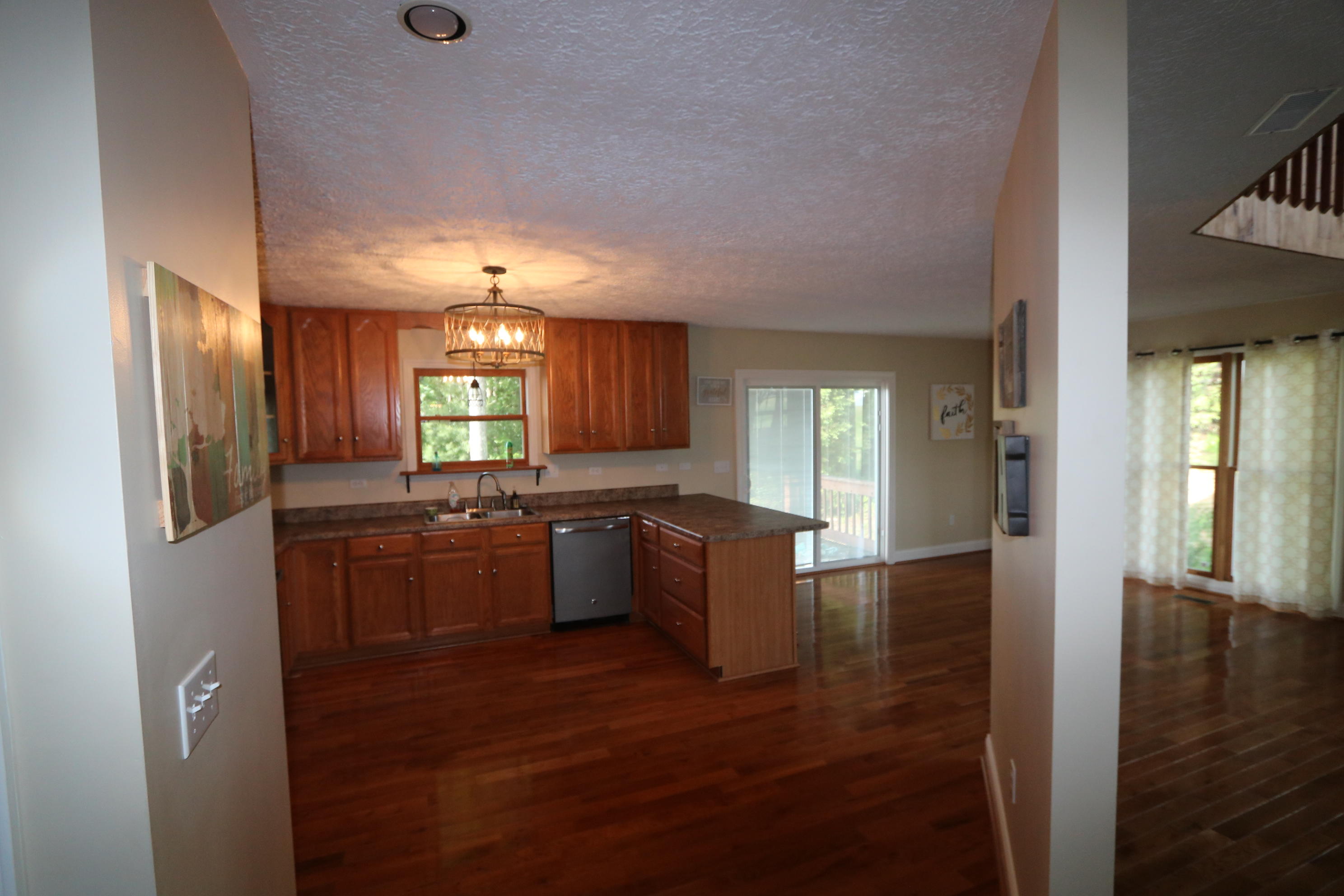 183 Midkiff Road Southeast Floyd, VA 24091 - Photo 12 of 35 a large kitchen with kitchen island granite countertop a refrigerator a sink dishwasher a stove and a dining table with wooden floor