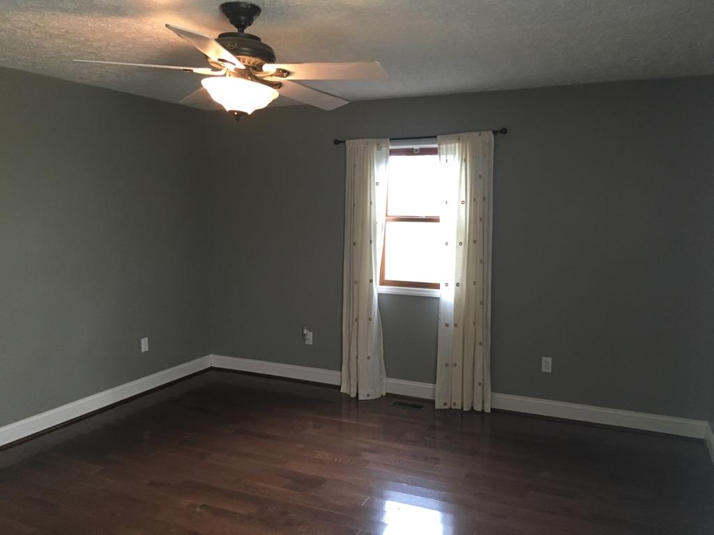 183 Midkiff Road Southeast Floyd, VA 24091 - Photo 15 of 35 an empty room with wooden floor fan and windows