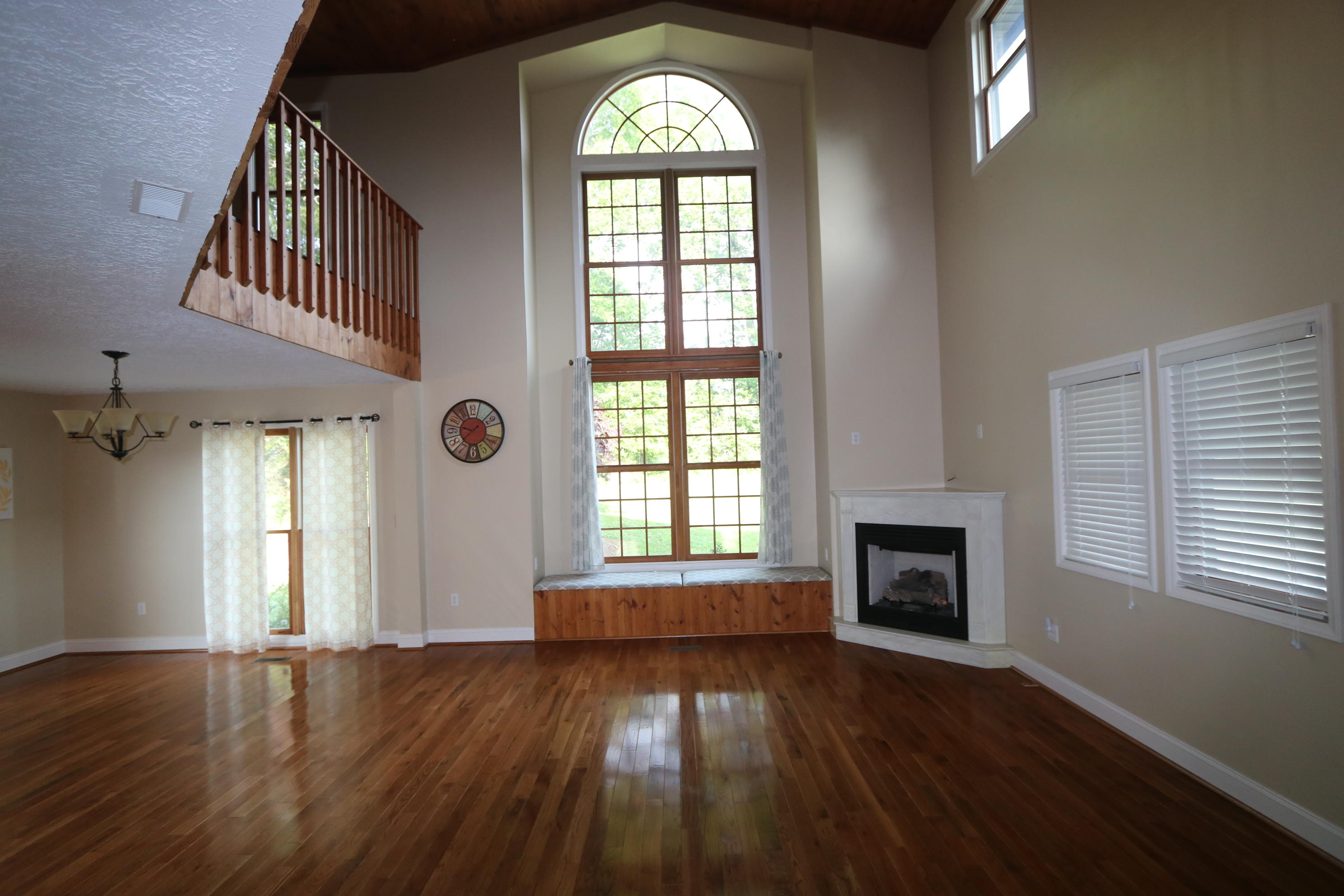 183 Midkiff Road Southeast Floyd, VA 24091 - Photo 7 of 35 an empty room with wooden floor a fireplace and windows