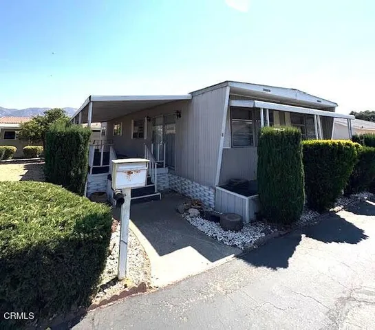 a view of a house with backyard and sitting area
