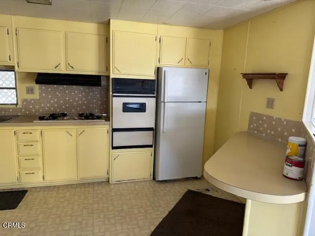 a kitchen with stainless steel appliances a stove a refrigerator and cabinets