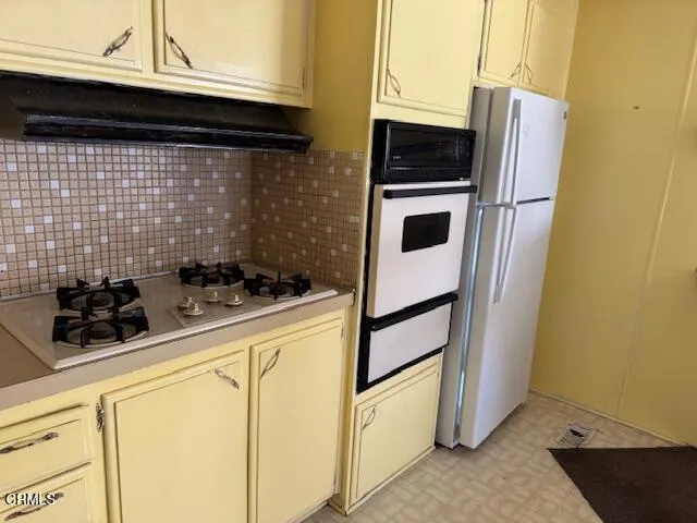 a kitchen with a stove and a refrigerator