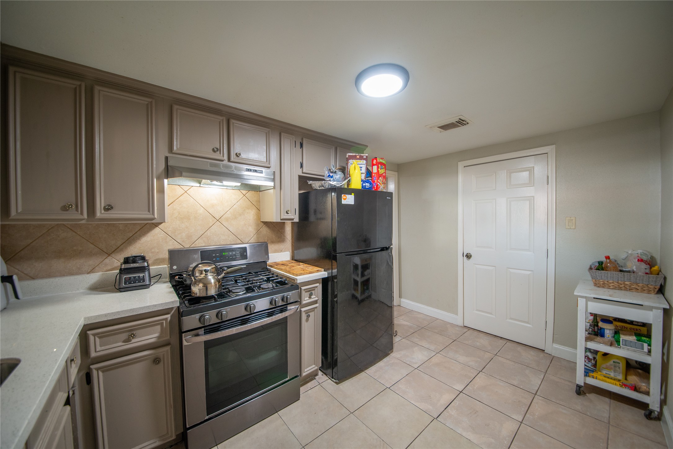 6309 East Houston Road Houston, TX 77028 - Photo 16 of 17 a kitchen with stainless steel appliances granite countertop a stove and a refrigerator