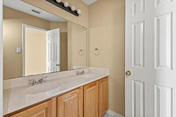 a bathroom with a granite countertop sink and a mirror