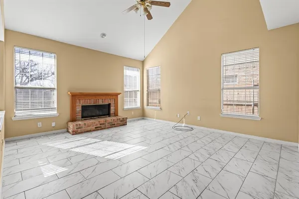 a view of empty room with fireplace and window