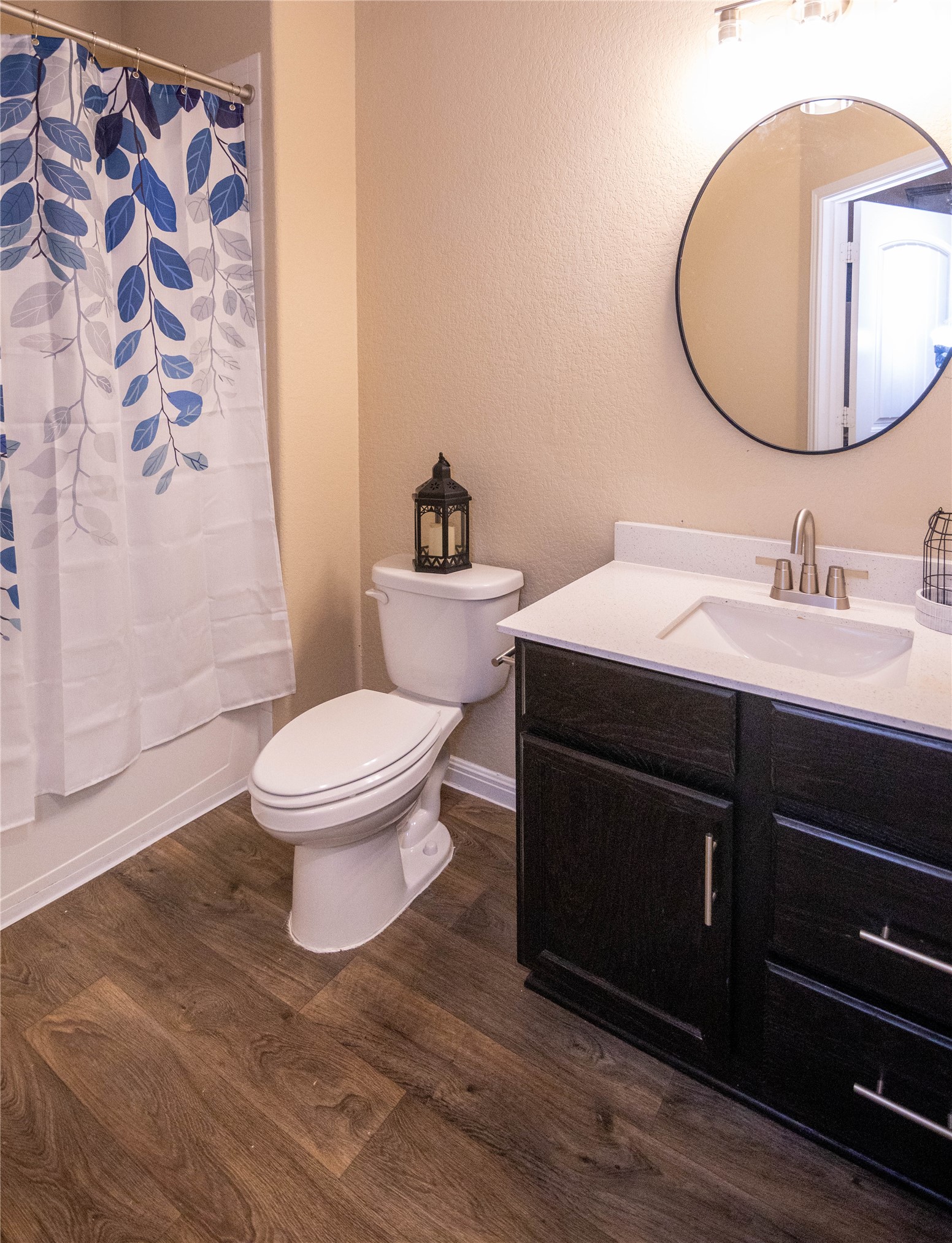 1501 Gropius Lane, Unit 30B Pflugerville, TX 78660 - Photo 20 of 30 Bathroom with vanity, a textured wall, shower / bath combination with curtain, and dark wood-style flooring