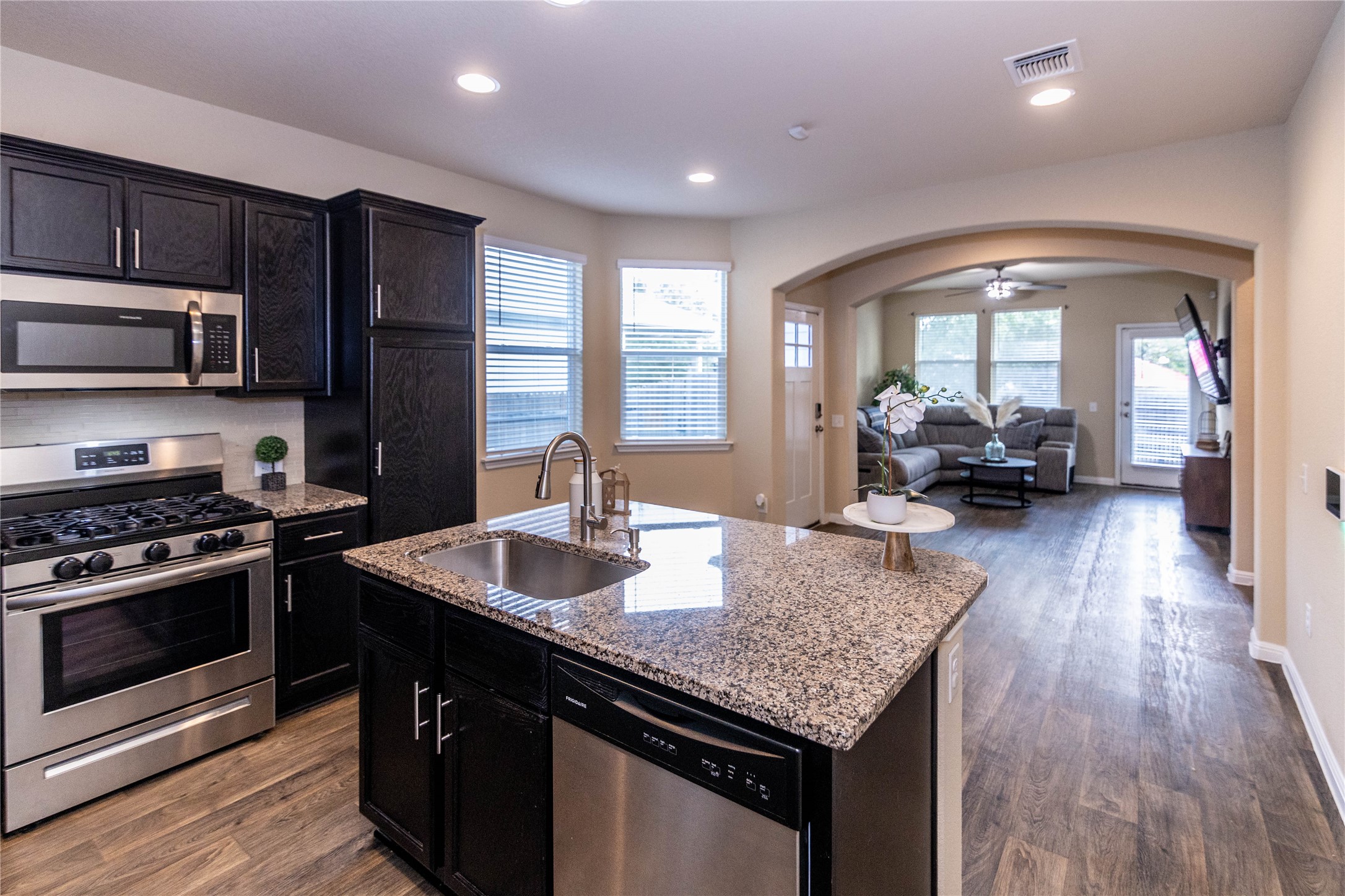 1501 Gropius Lane, Unit 30B Pflugerville, TX 78660 - Photo 30 of 30 Kitchen featuring appliances with stainless steel finishes, dark wood-style floors, open floor plan, arched walkways, and recessed lighting
