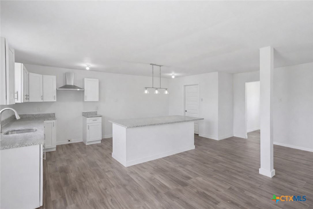 950 Highsmith Road Luling, TX 78648 - Photo 16 of 36 a large kitchen with a wooden floor and a sink
