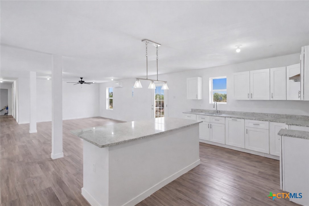 950 Highsmith Road Luling, TX 78648 - Photo 17 of 36 a kitchen with stainless steel appliances granite countertop a sink dishwasher a refrigerator and white cabinets with wooden floor