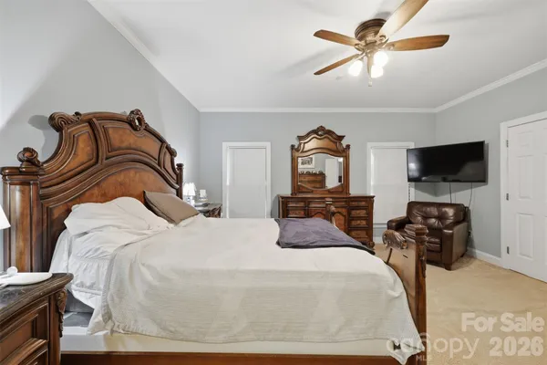 a bedroom with a bed and a flat tv screen on the dresser