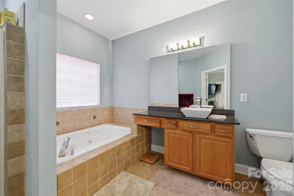 a bathroom with a sink a large mirror and a bathtub