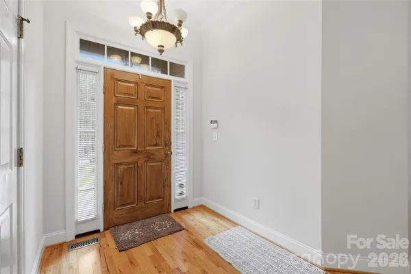 an empty room with wooden floor closet and windows