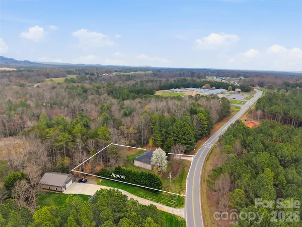 an aerial view of a house with a yard and lake view