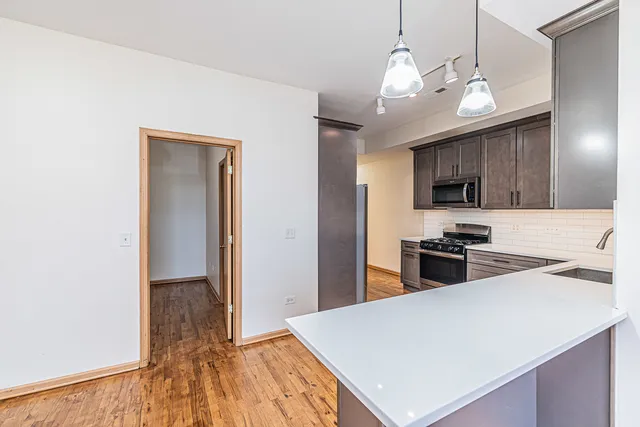 a kitchen with stainless steel appliances a stove refrigerator and a sink