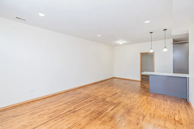 a view of empty room with wooden floor
