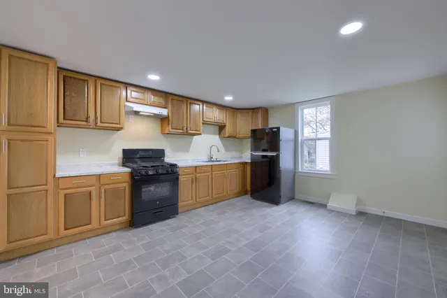 a kitchen with stainless steel appliances granite countertop a sink counter space and cabinets