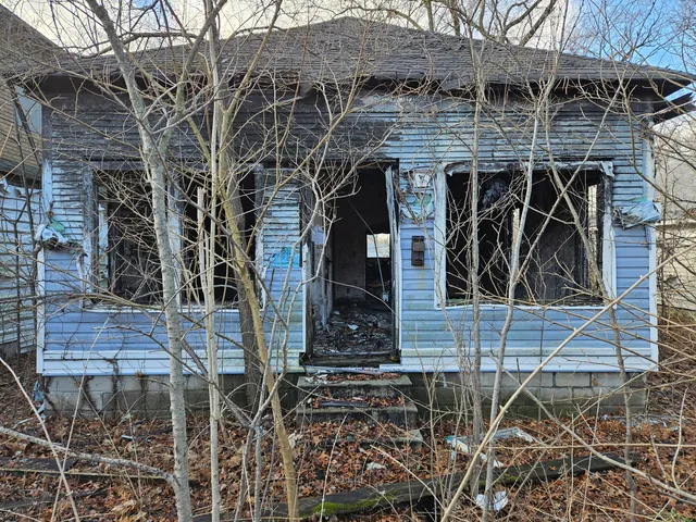 a view of a wooden door with a bench in front of house