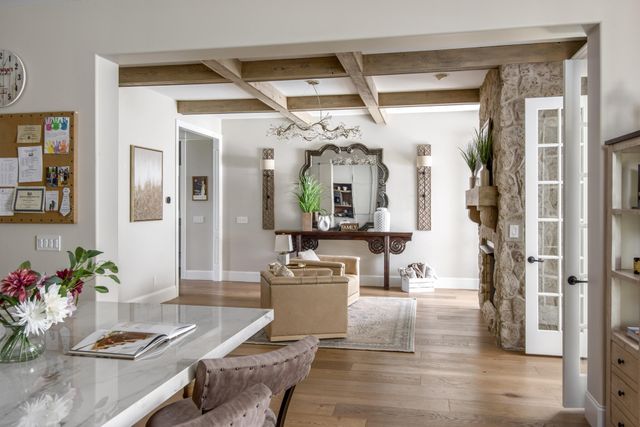 a spacious bedroom with a large bed a chandelier and windows