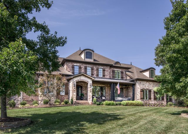 a view of a big building with a big yard and large trees
