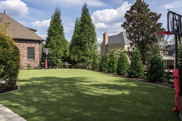 a view of swimming pool with lawn chairs under an umbrella