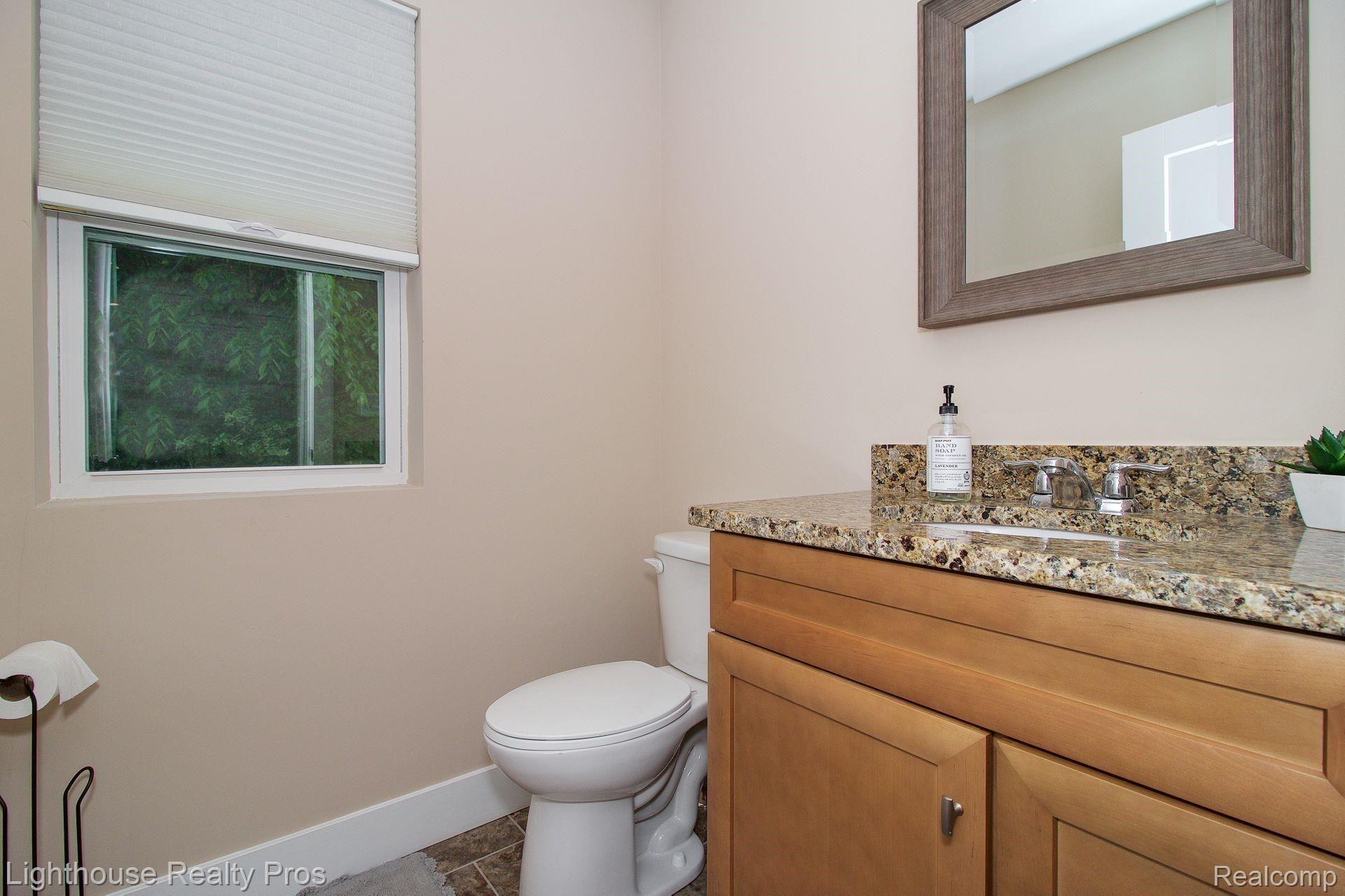 2897 Fisher Road Howell, MI 48855 - Photo 17 of 37 Main level powder room with granite counter and ceramic floor