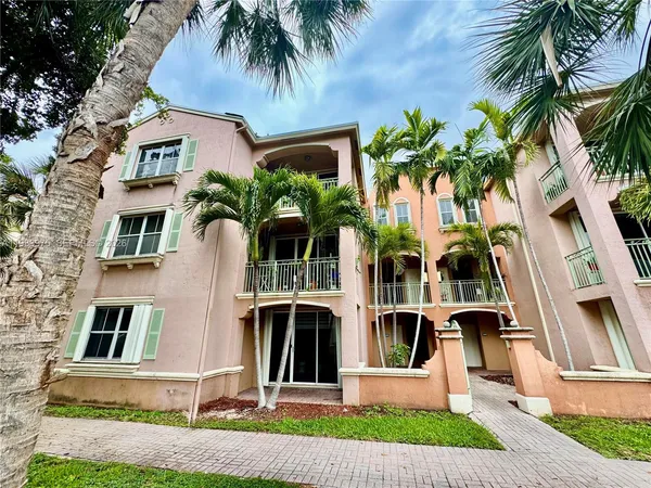 front view of house with a yard and palm trees