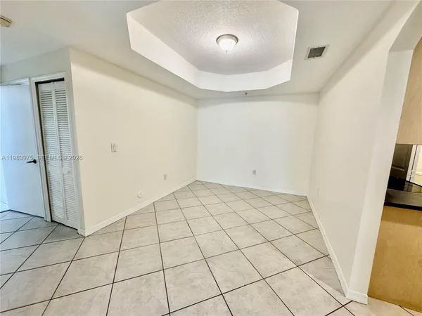 a kitchen with granite countertop a stove top oven a sink a refrigerator and white cabinets