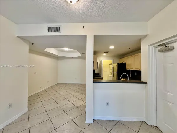 a kitchen with granite countertop a sink a stove and cabinets