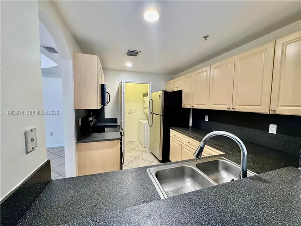 a kitchen with stainless steel appliances kitchen island granite countertop a stove a sink and a microwave