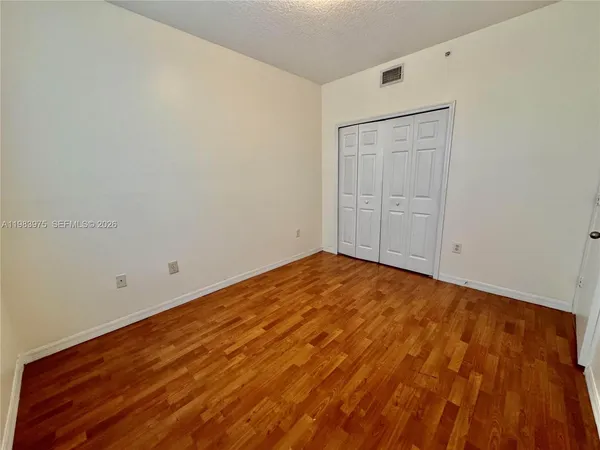 a view of a swimming pool with a lawn chairs under palm trees