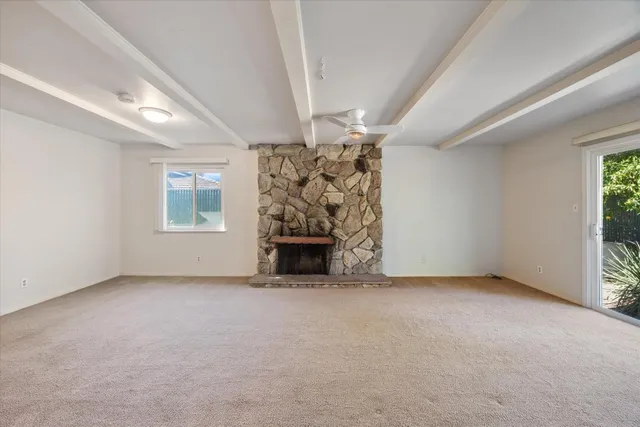 an empty room with a fireplace and window