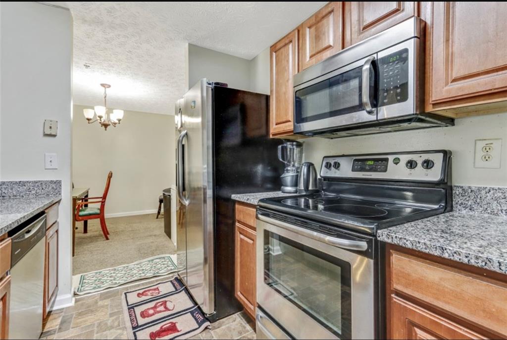 a kitchen with stainless steel appliances granite countertop a stove microwave and refrigerator