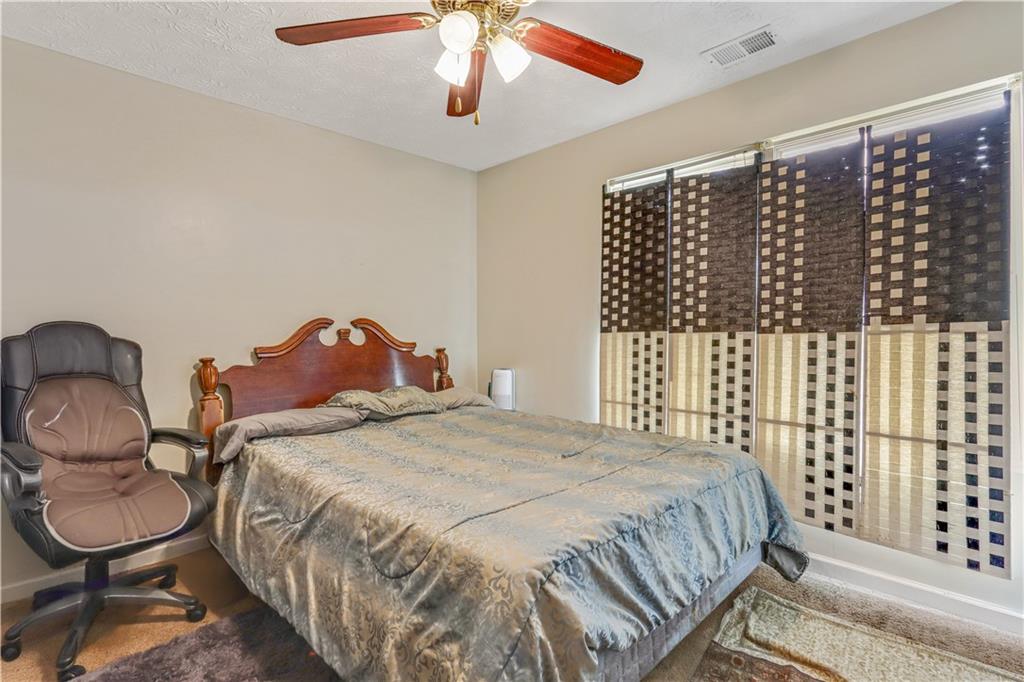 12303 Waldrop Place Decatur, GA 30034 - Photo 7 of 11 a bedroom with a bed and a chandelier