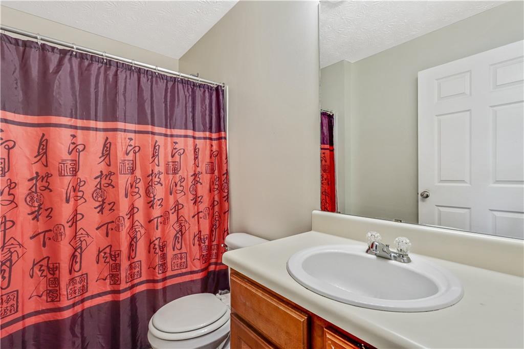 12303 Waldrop Place Decatur, GA 30034 - Photo 9 of 11 a bathroom with a sink a toilet and shower curtain