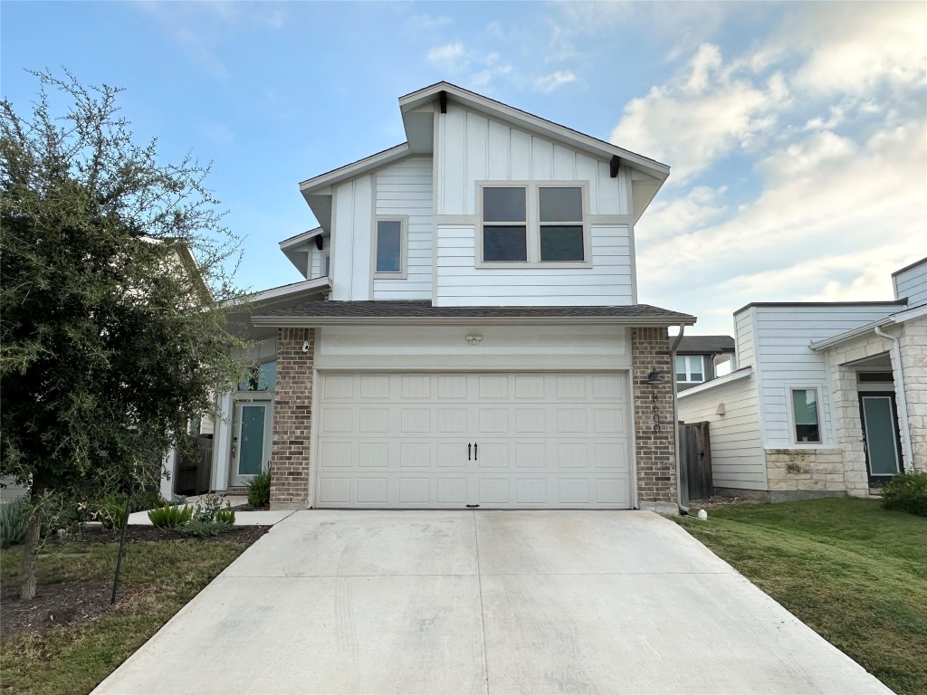8600 Cumbrae Lane Austin, TX 78744 - Photo 1 of 29 View of front facade featuring brick siding, driveway, a garage, board and batten siding, and a front yard