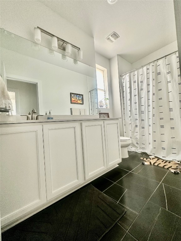 8600 Cumbrae Lane Austin, TX 78744 - Photo 10 of 29 Bathroom with double vanity and dark tile patterned floors