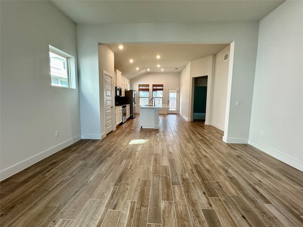 8600 Cumbrae Lane Austin, TX 78744 - Photo 7 of 29 Unfurnished living room with vaulted ceiling, dark wood-style floors, and recessed lighting