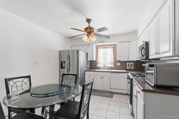 a kitchen with stainless steel appliances a dining table and chairs