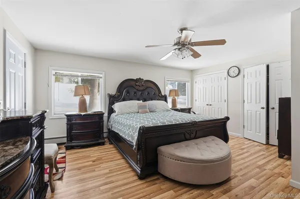 a spacious bedroom with a bed and wooden floor