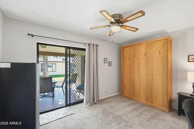 a view of a workspace with furniture and a ceiling fan