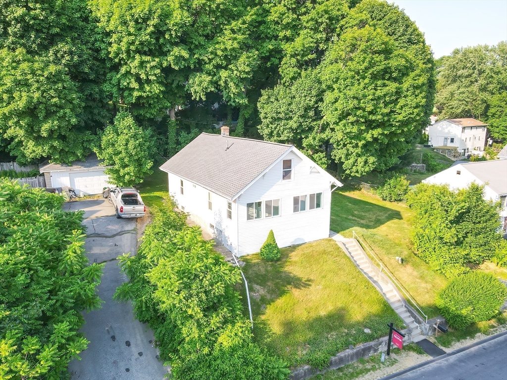 a view of a house with a yard and potted plants