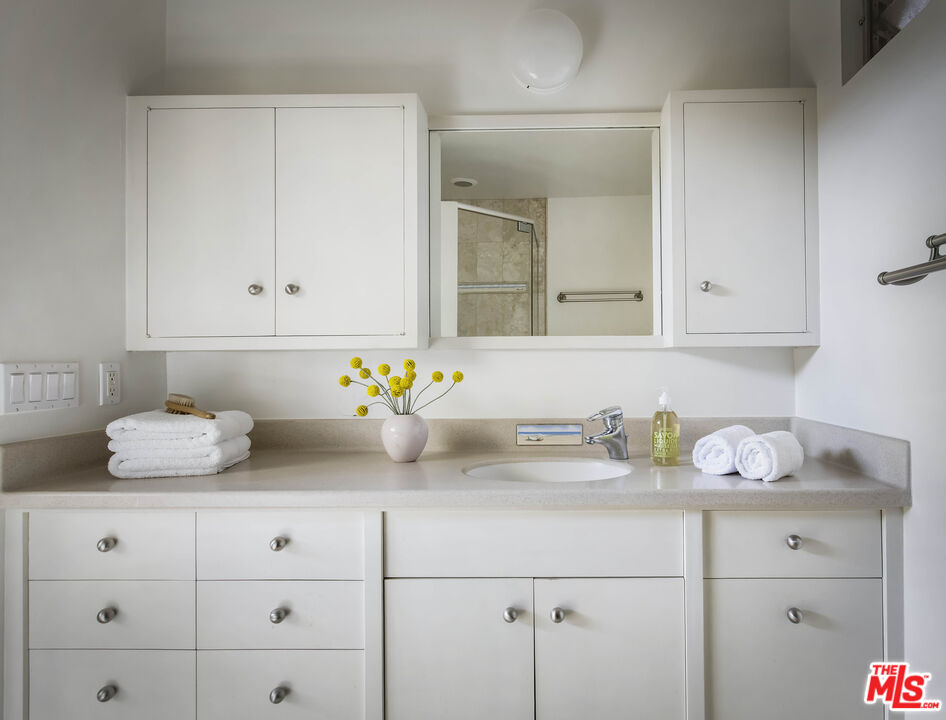921 North San Marcos Road Santa Barbara, CA 93111 - Photo 36 of 44 a bathroom with a granite countertop white cabinets and a potted plant