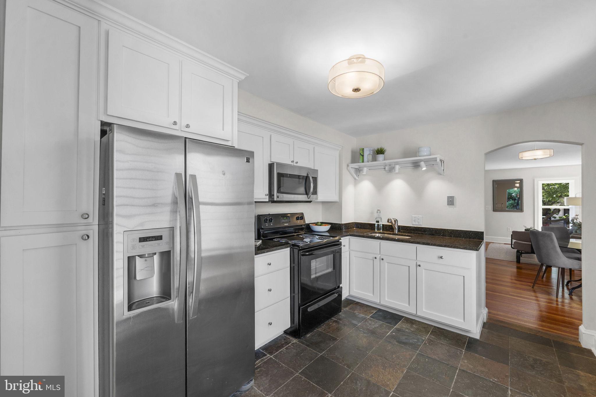 914 15th Street Southeast Washington, DC 20003 - Photo 12 of 37 a kitchen with stainless steel appliances granite countertop a refrigerator a sink a stove a dining table and chairs
