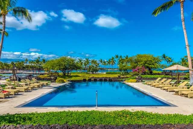 a view of a swimming pool with an outdoor seating and a yard