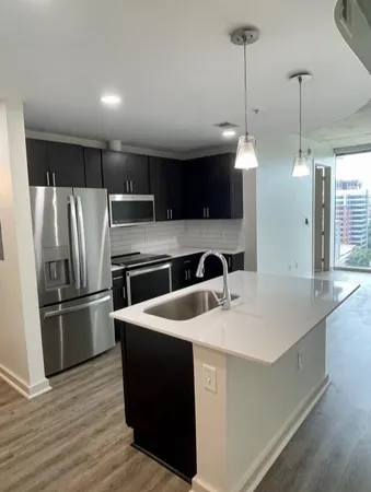 a kitchen with kitchen island a sink appliances and cabinets