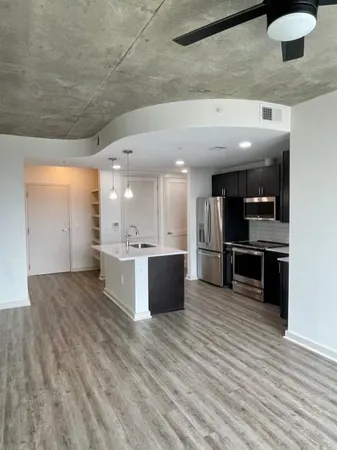 a large kitchen with stainless steel appliances kitchen island a large counter top a stove a refrigerator and a sink