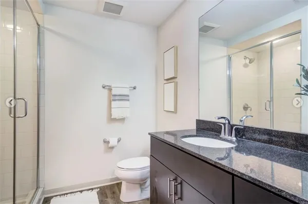 a bathroom with a granite countertop sink toilet and shower